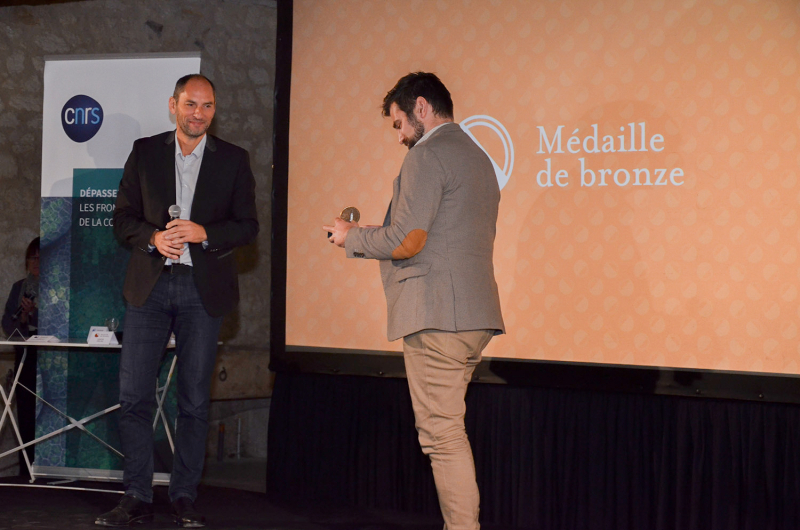 Vincent Poireau remet la médaille de bronze du CNRS à Vivian Poulin-Détolle