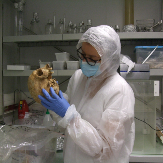 Samantha Brunel examinant un crâne dans le laboratoire de haut confinement de l’Institut Jacques Monod (CNRS/Université de Paris)