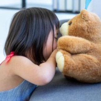 Petite fille se consolant avec son nounours